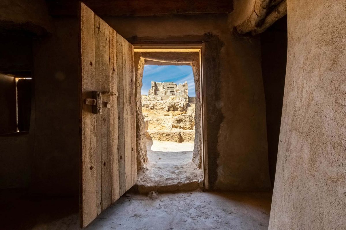 Temple of Amun through the doors of a mosque in Siwa, Egypt