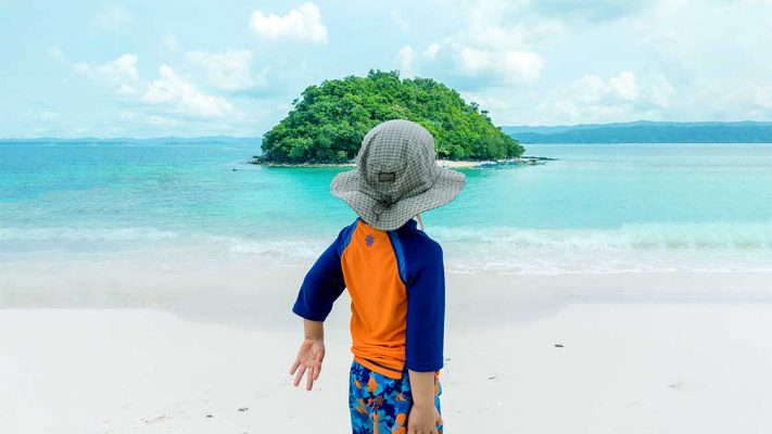 Young boy looking out at an island in the Philippines
