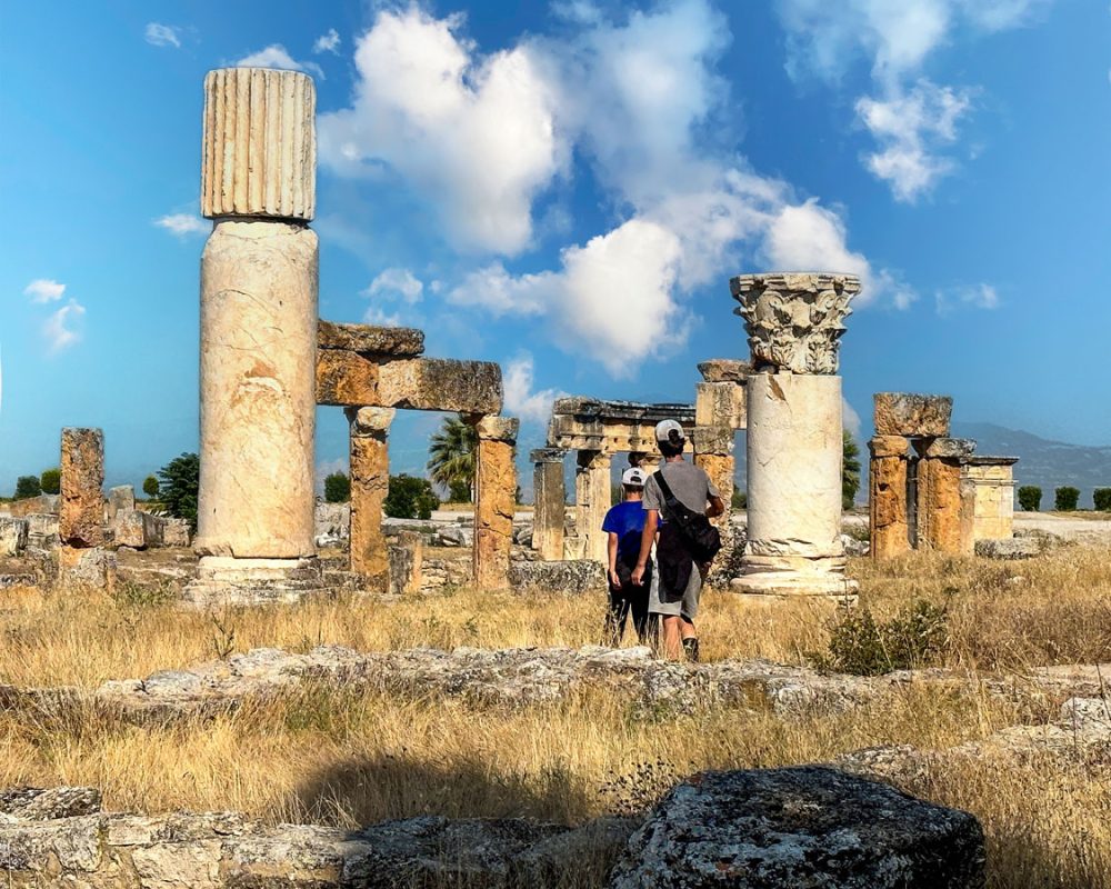 Two boys stroll through the ruins of Roman columns and buildings at Heirapolis