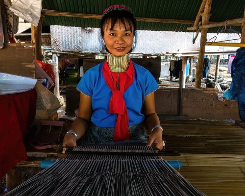 A woman from the Karen Hills Tribe weaves fabric in her village