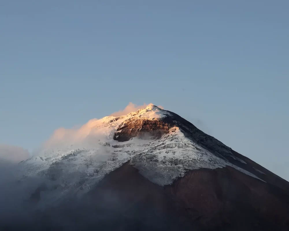 The summit of a glacier-capped Cotopaxi Volcano at dusk
