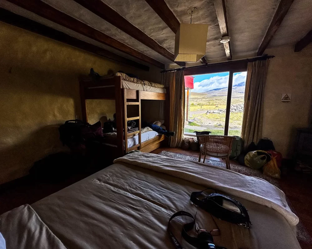 Inside a room at Tambopaxi Lodge with a window looking out over Cotopaxi National Park