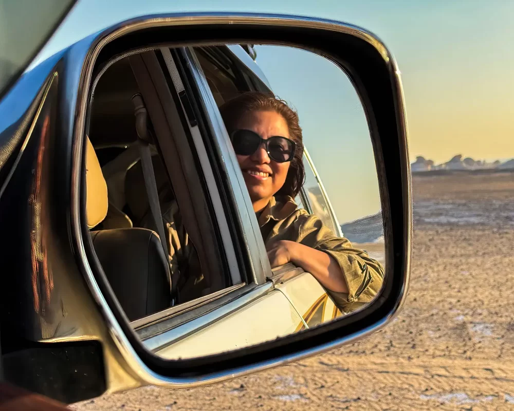 Christina Wagar in rearview mirror of landcruiser in Egypts Western Desert