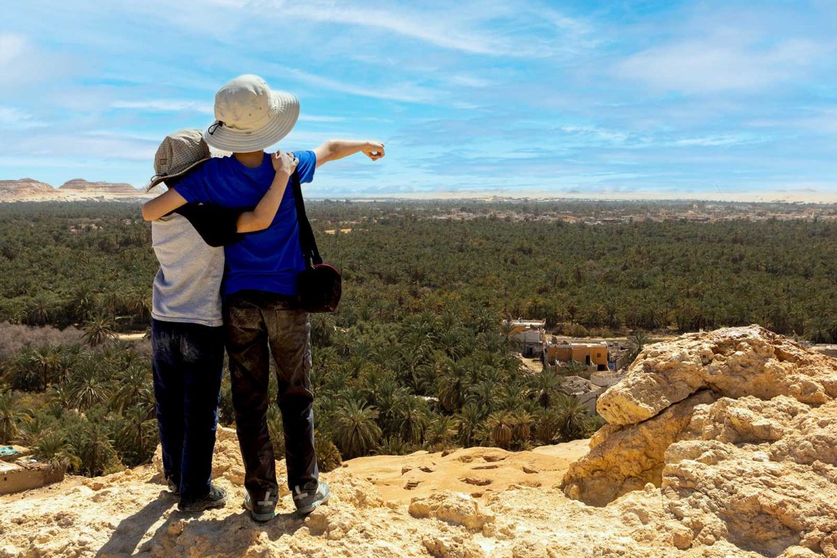 Two children look and point over the town of Siwa Egypt
